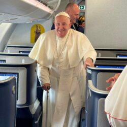 Pope Francis smiles as he boards the papal plane