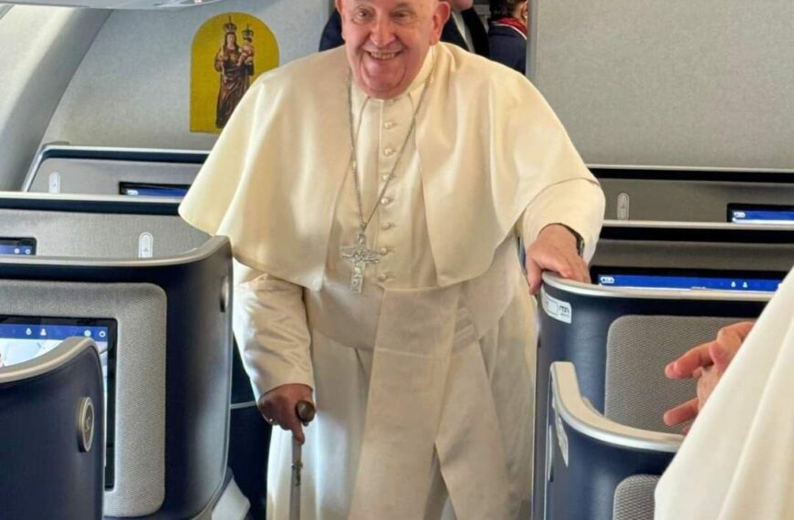 Pope Francis smiles as he boards the papal plane