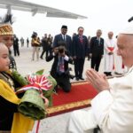 Pope Francis greeting journalists aboard the papal flight to Jakarta