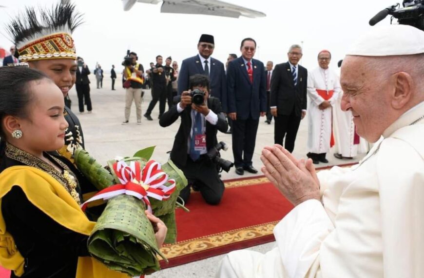 Pope Francis greeting journalists aboard the papal flight to Jakarta