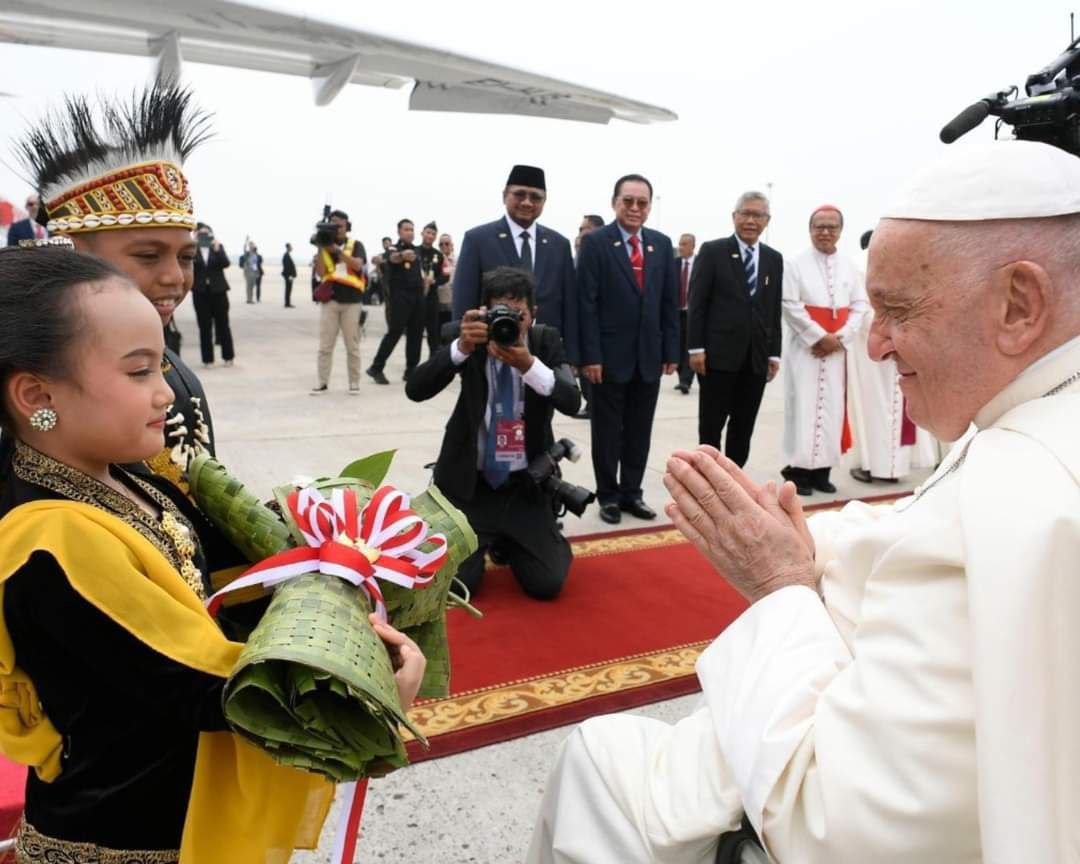 Pope Francis greeting journalists aboard the papal flight to Jakarta