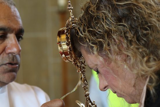 Msgr. Anthony Figueiredo, director of international affairs of the Diocese of Assisi, Italy, blesses pilgrim Natalie Orefice with a relic of the heart of Blessed Carlo Acutis during public veneration Sept. 21, 2024, at St. Anthony’s Church in Manchester,